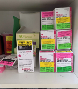Boxes of Narcan nasal spray sit in a clinic supply closet.