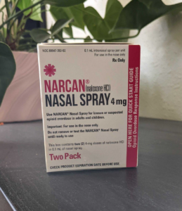 A box of Narcan nasal spray sits on top of a bookshelf.